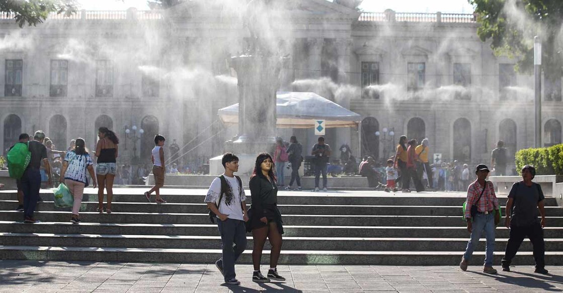 EL-SALVADOR-WEATHER People walk as water is sprayed by a system to reduce the high temperatures caused by a heat wave, at the Gerardo Barrios square, in San Salvador, El Salvador. Photo: REUTERS/Jose Cabezas/File