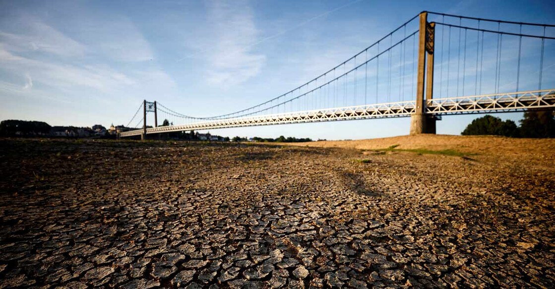 Cracked and dry earth is seen in the wide riverbed of the Loire River near the Anjou-Bretagne bridge in Ancenis-Saint-Gereon, France. Photo: REUTERS/Stephane Mahe/File