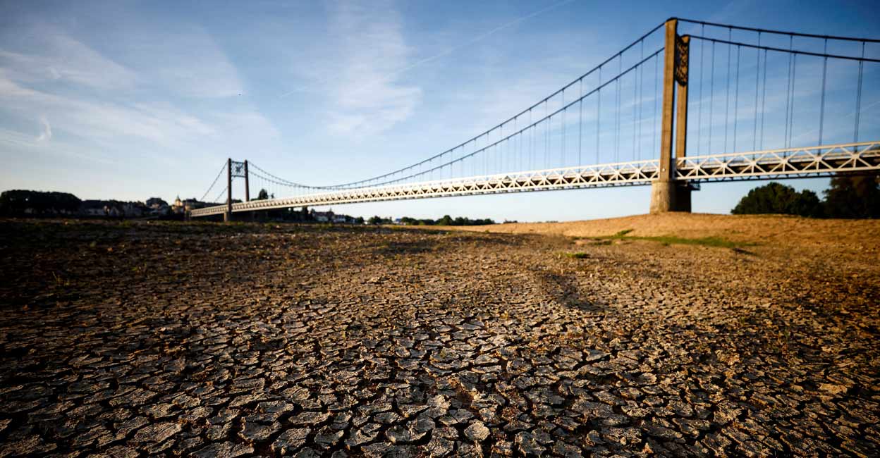 Cracked and dry earth is seen in the wide riverbed of the Loire River near the Anjou-Bretagne bridge in Ancenis-Saint-Gereon, France. Photo: REUTERS/Stephane Mahe/File