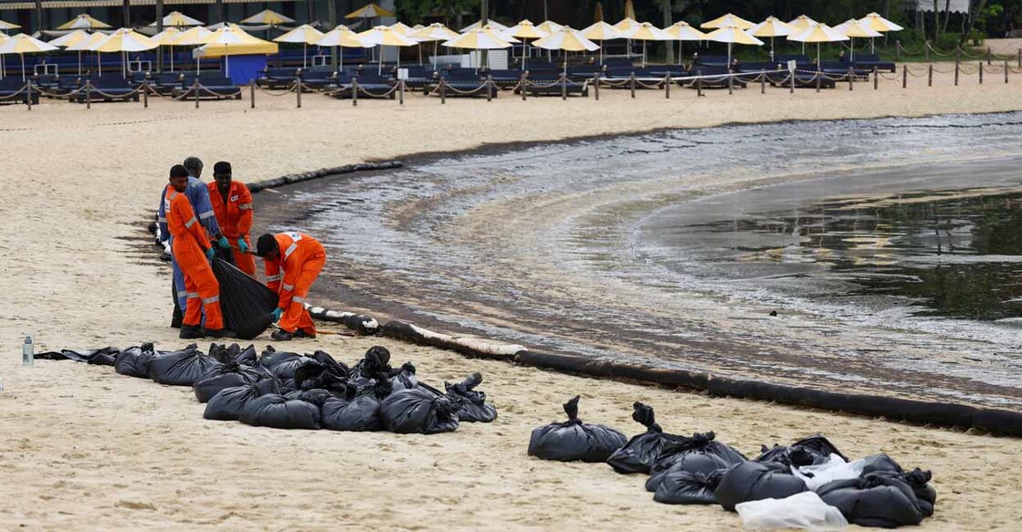 Workers clean up the oil slick at Tanjong Beach in Sentosa, Singapore. Photo: Reuters/Edgar Su