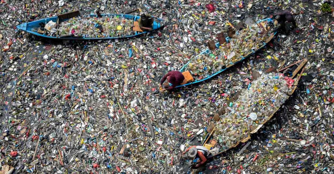 People on boats collect recyclable plastics from the heavily polluted Citarum River at Batujajar in Bandung, West Java. Image used for representational purpose. Photo: TIMUR MATAHARI / AFP