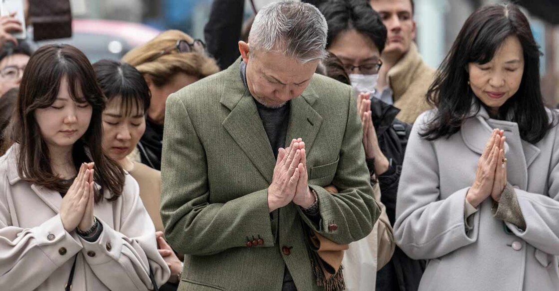 People pray as they take part in a minute of silence to remember the victims on the 14th anniversary of the 2011 earthquake, tsunami and nuclear disaster, in the Ginza shopping district of Tokyo. Photo: Yuichi YAMAZAKI / AFP