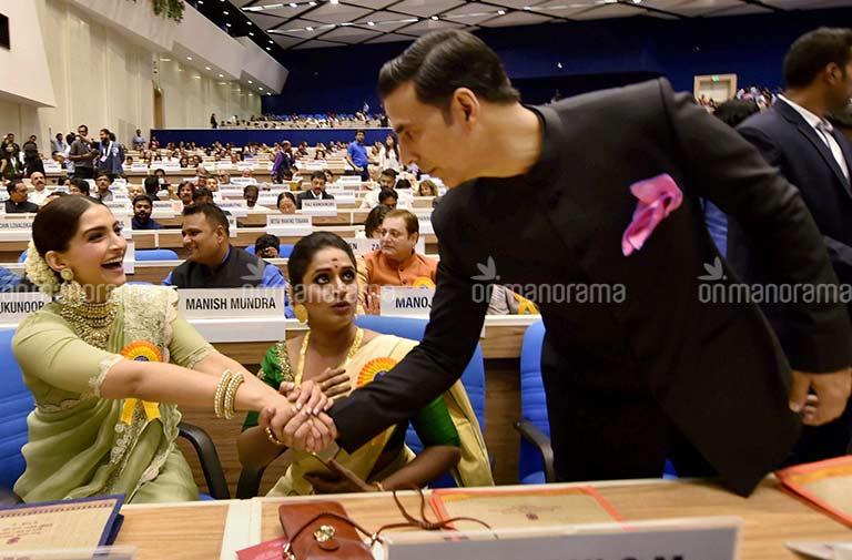 64th National Film Awards Best Actor award winner Akshay Kumar greets actress Sonam Kapoor as Best actress award winner Surabhi looks on, at the 64th National Film Awards function at Vigyan Bhavan in New Delhi on Wednesday. PTI