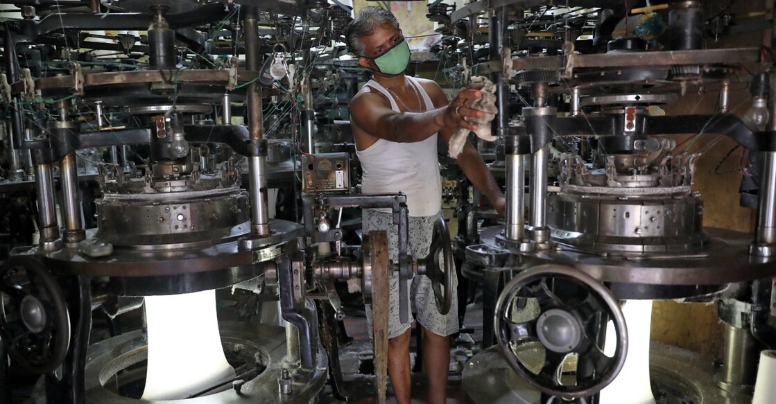A worker wearing a protective face mask cleans a machine inside an undergarment factory after it was re-opened after a weeks-long shutdown to slow the spread of coronavirus disease (COVID-19), in Kolkata, April 20, 2020. REUTERS/Rupak De Chowdhuri/Files