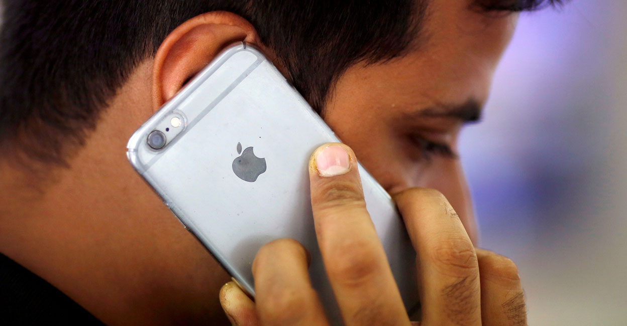 A man talks on his iPhone at a mobile phone store in New Delhi, India, July 27, 2016. Photo: REUTERS/Adnan Abidi