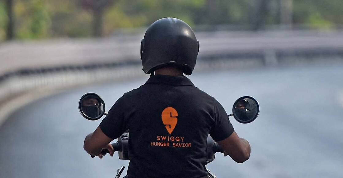 A delivery man working with Swiggy, an online food delivery application, rides his bike on a deserted road to deliver an order in Mumbai on April 7, 2020. Photo: Punit Paranjpe/AFP
