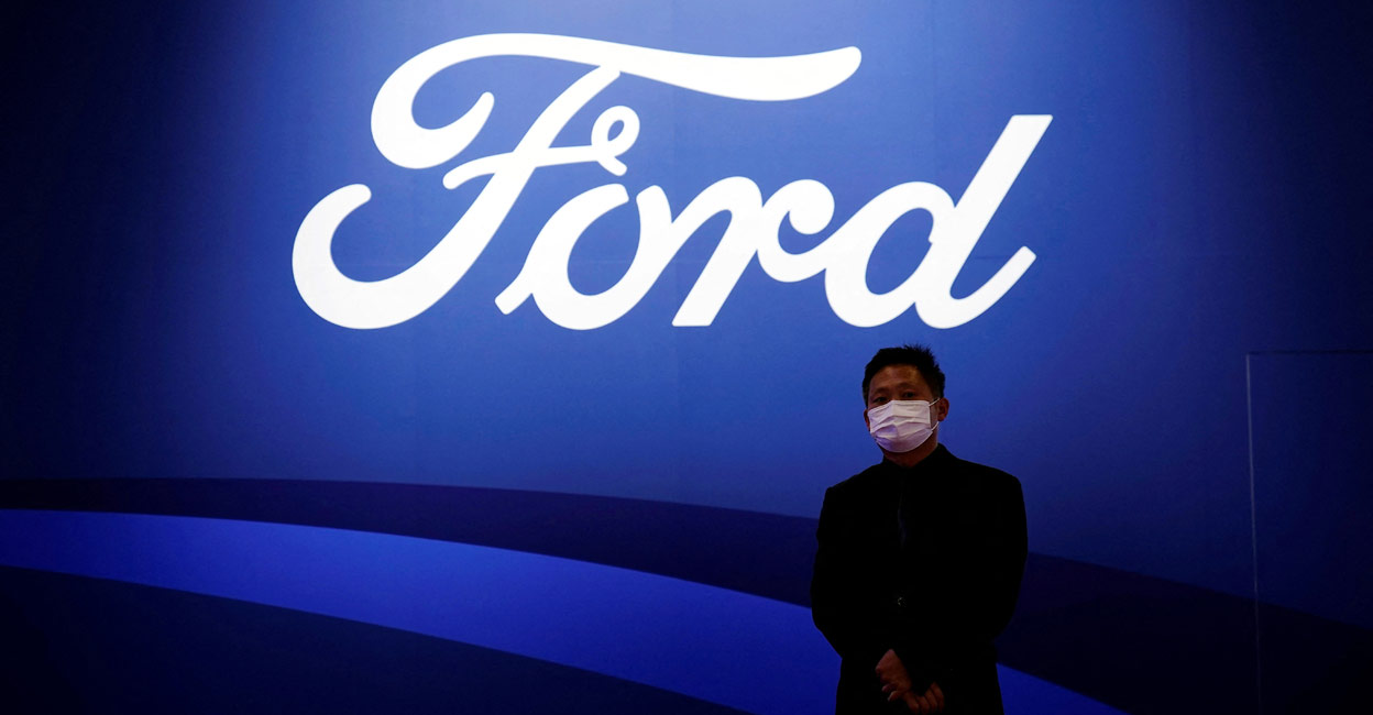 A man stands near the Ford logo during a media day for the Auto Shanghai show. File Photo: Reuters/Aly Song