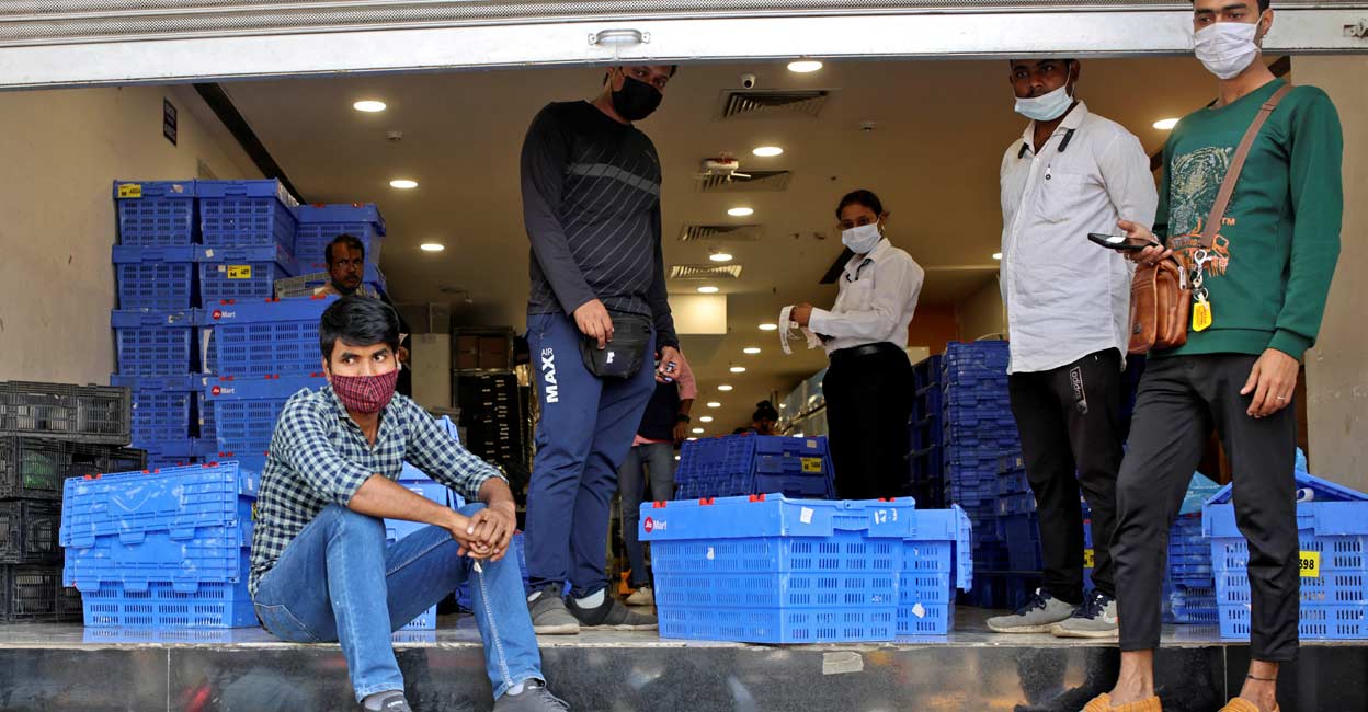 AMAZON-COM-INDIA-FUTURE-RELIANCE Workers from Reliance's JioMart take a break as they stock their products inside a Future Retail's closed Big Bazaar retail store in Mumbai, March 2, 2022. Picture taken March 2, 2022. Photo: REUTERS/Francis Mascarenhas