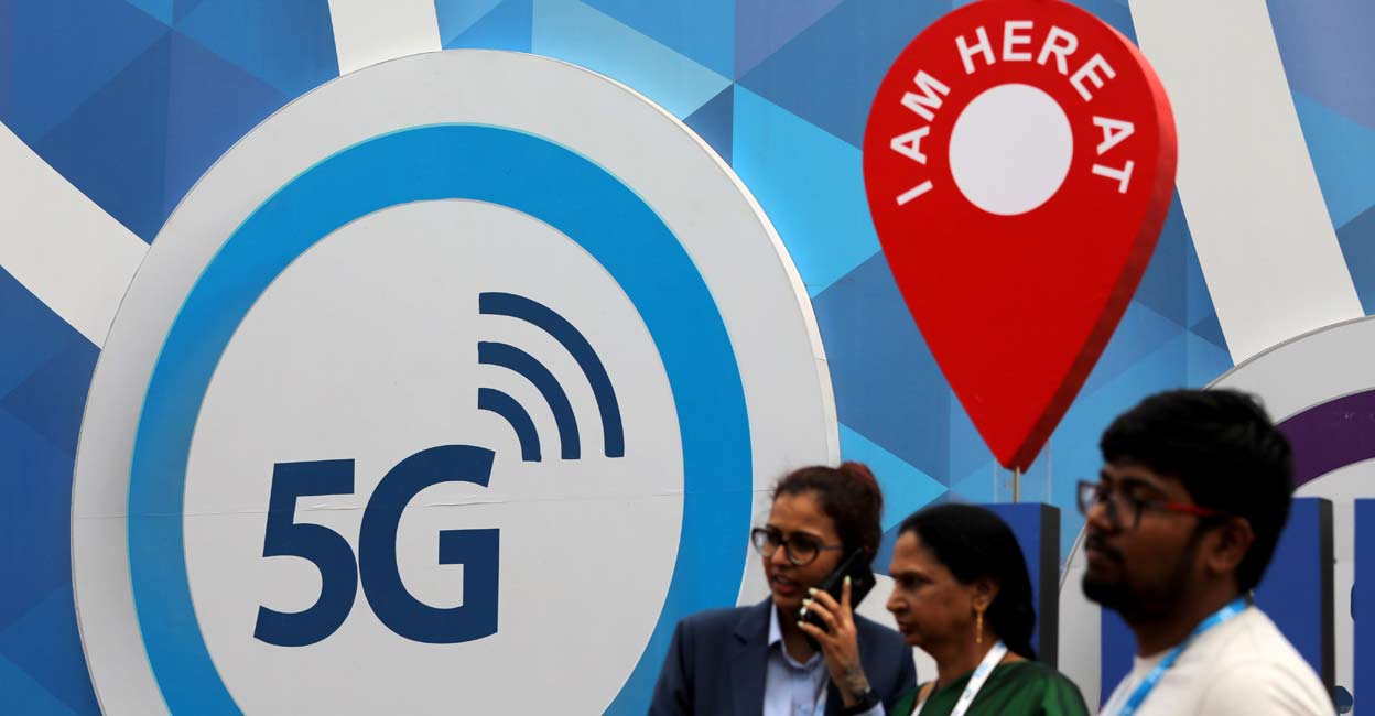 FILE PHOTO: People stand in front of a board depicting 5G network at the India Mobile Congress 2018 in New Delhi, India, October 26, 2018. REUTERS/Anushree Fadnavis