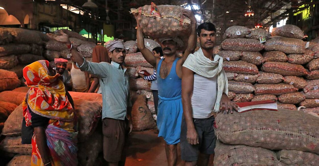 A labourer carries a sack of onions at a wholesale market in Kolkata, India, December 14, 2021. Photo: Rupak De Chowdhuri/Reuters