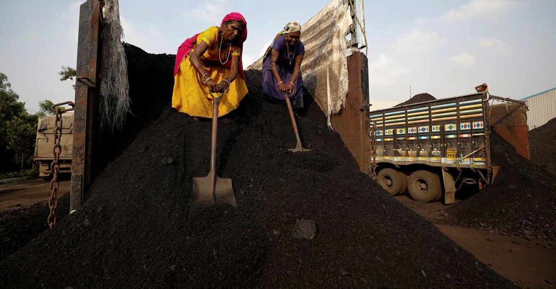 Workers unload coal from a supply truck at a yard on the outskirts of Ahmedabad. Photo: Reuters/Amit Dave