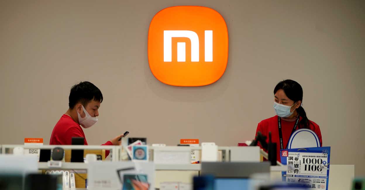 ED seizes Rs 5,551 cr deposits of smartphone giant Xiaomi India for FEMA violation Staff members stand near the company logo at a Xiaomi store in Shanghai, China November 1, 2021. Photo: Reuters/Aly Song/Files