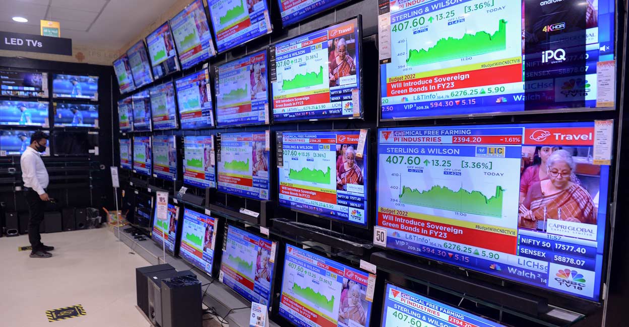 A staff at an electronics goods showroom watch the telecast of union budget being presented by India's Finance minister on the displayed television sets at a showroom in Mumbai on February 1, 2022. Photo: Indranil Mukherjee/AFP