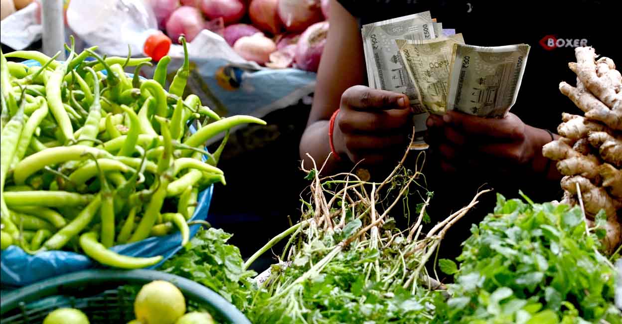 A vegetable vendor counts money in Mumbai. Photo: Indranil Mukherjee/AFP
