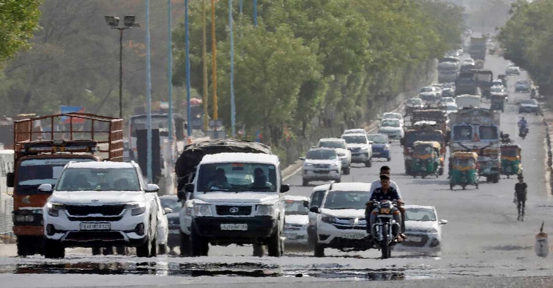 Traffic moves on a road in a heat haze during hot weather on the outskirts of Ahmedabad, May 12, 2022. Photo: Amit Dave/Reuters