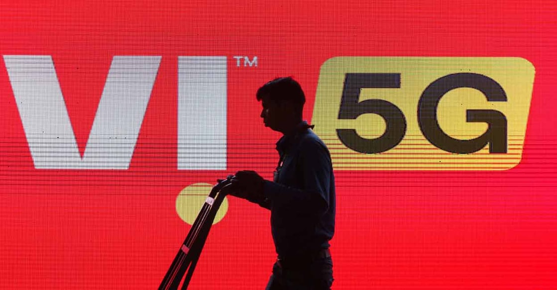 A man walks across the LED display board showing the logo of Vodafone-Idea at Pragati Maidan in New Delhi. File photo: Reuters/ Anushree Fadnavis
