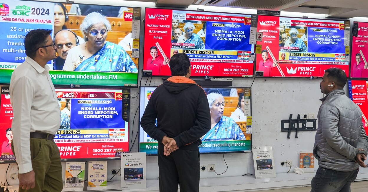 People watch Union Finance Minister Nirmala Sitharaman presenting the Interim Budget 2024 in Parliament, at a television showroom in Kolkata. Photo: PTI