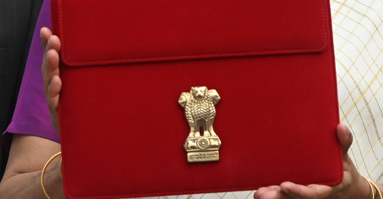 Union Finance Minister Nirmala Sitharaman displays a red pouch carrying the Budget documents outside the Finance Ministry in North Block before leaving for the Parliament where she will table the Union Budget 2024-25, in New Delhi, Tuesday, July 23, 2024. Photo: PTI. 