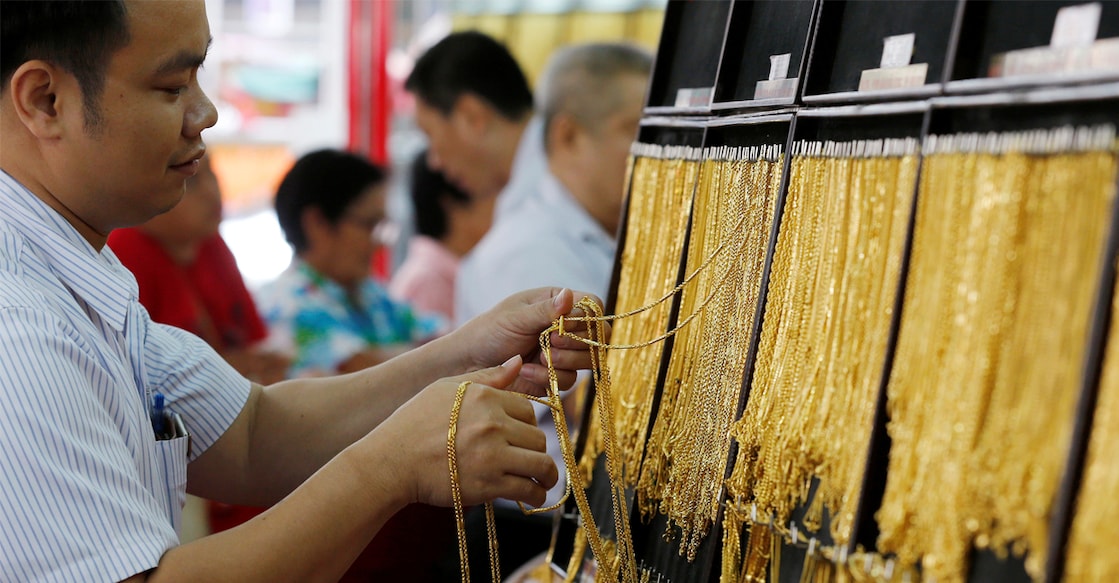 Representational image of a salesman choosing gold chains for people at a gold shop in Bangkok, Thailand. Photo: REUTERS/Chaiwat Subprasom