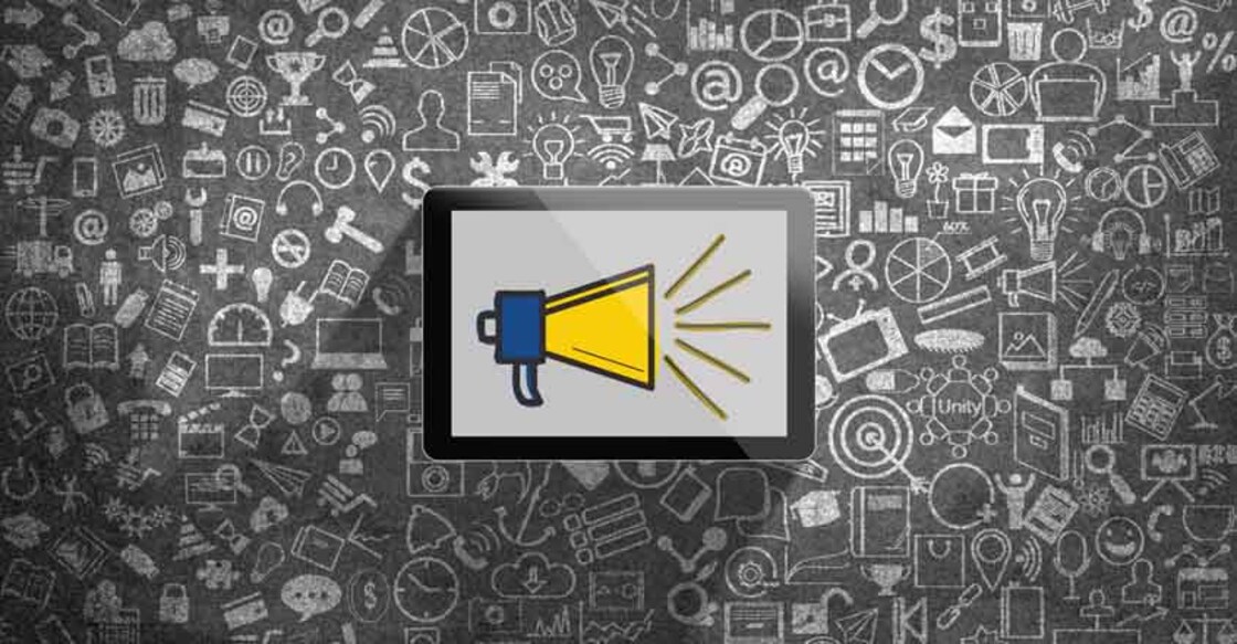 Megaphone icon on digital tablet in front of chalkboard Megaphone icon on digital tablet in front of chalkboard