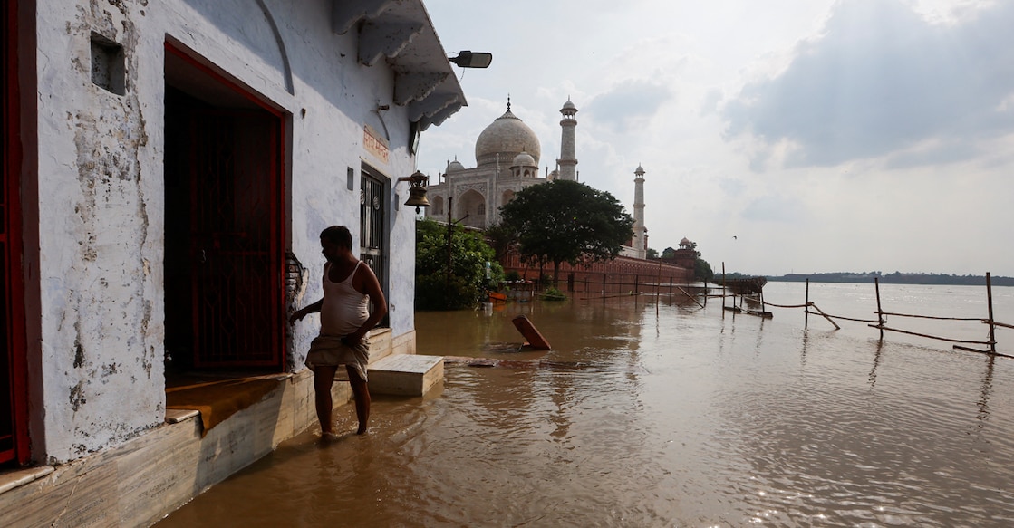 A priest walks in flood waters in front of a temple near the Taj Mahal as the Yamuna river overflows following heavy rains, in Agra. Photo: Reuters/Adnan Abidi