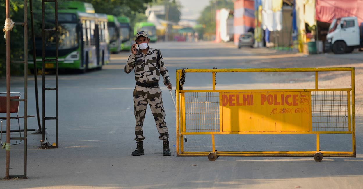 A security person keeps vigil at Singhu Border near the site of the farmers' protest. Photo: PTI