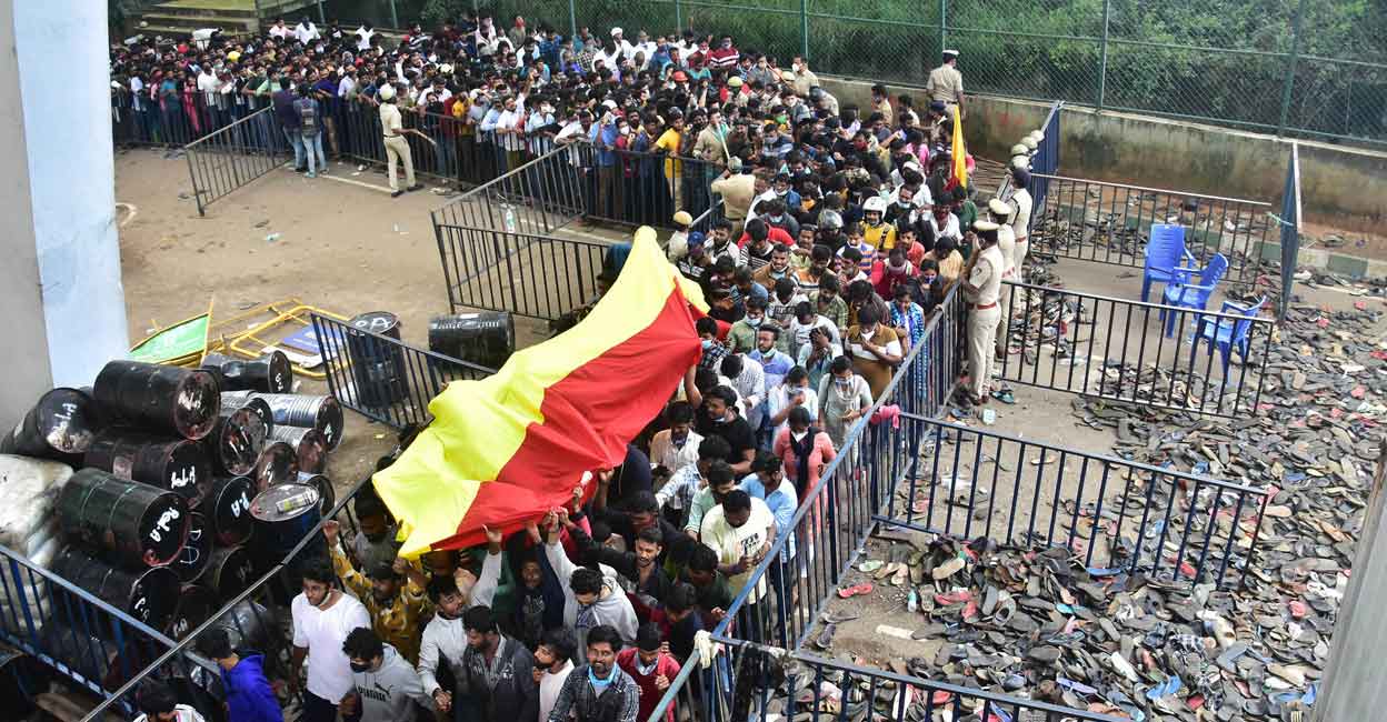 PTI10_30_2021_000254B Fans carry a Kannada flag as they stand in queue to pay their last respects to the mortal remains of Kannada film actor Puneeth Rajkumar at the Kanteerava Stadium, in Bengaluru, Saturday, Oct. 30, 2021. Phot: PTI