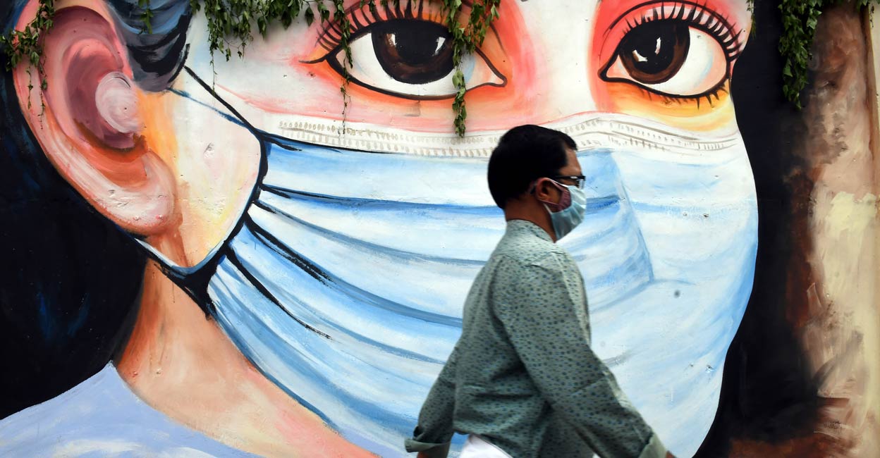 A man walk past a mural on novel coronavirus in Thiruvananthapuram, October 3 , 2021. Photo: PTI