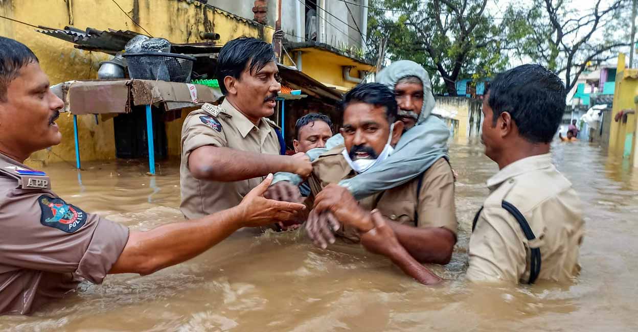 PTI11_19_2021_000344B A policeman carries an old man on his back to evacuate him from a flooded area at Rajampet in Kadapa district. Photo: PTI