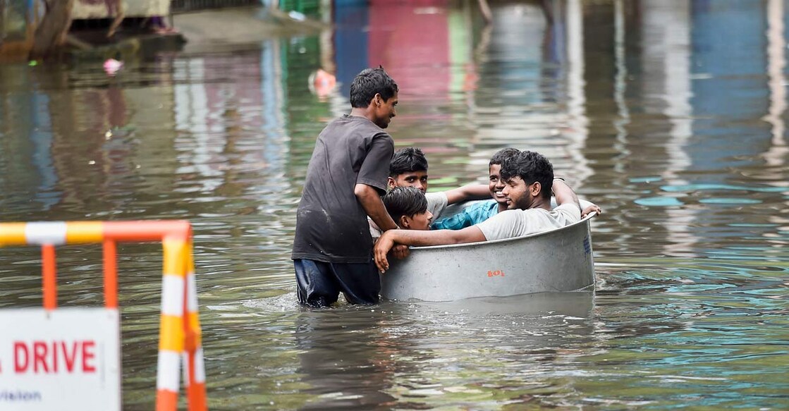 Young men sit in a tub as another man pushes them on a waterlogged street following heavy rain in Chennai, Saturday, Nov. 27, 2021. Photo: PTI