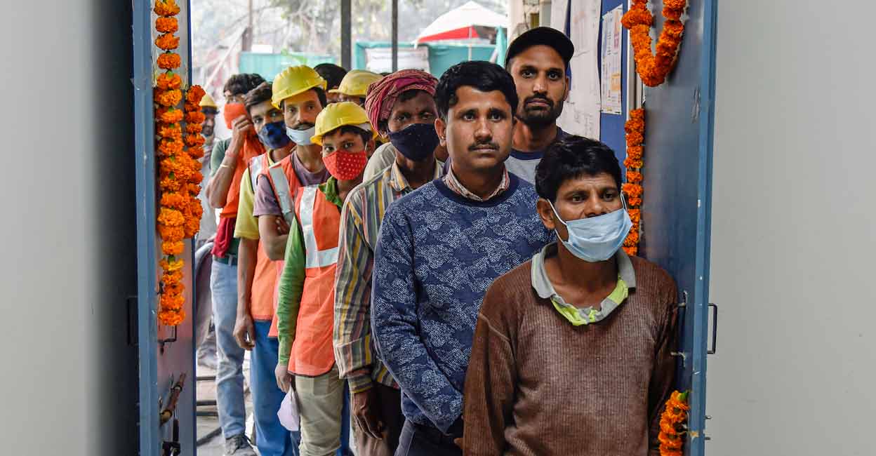 COVID-19 in India Labourers wait to receive a dose of COVID-19 vaccine after Union Minister Meenakshi Lekhi (unseen) inaugurated free vaccination camp for those working at the Central Vista construction site in New Delhi, Saturday, Nov. 27, 2021. Photo: PTI