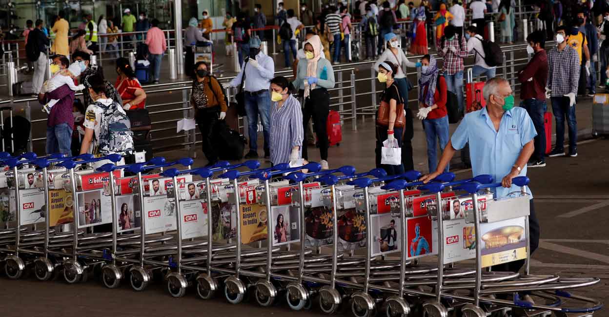 An airport staff member pushes trollies at the entrance of Chhatrapati Shivaji International Airport, after the government allowed domestic flight services to resume, during an extended nationwide lockdown to slow the spread of COVID-19, in Mumbai, May 25, 2020. Photo: REUTERS/Francis Mascarenhas
