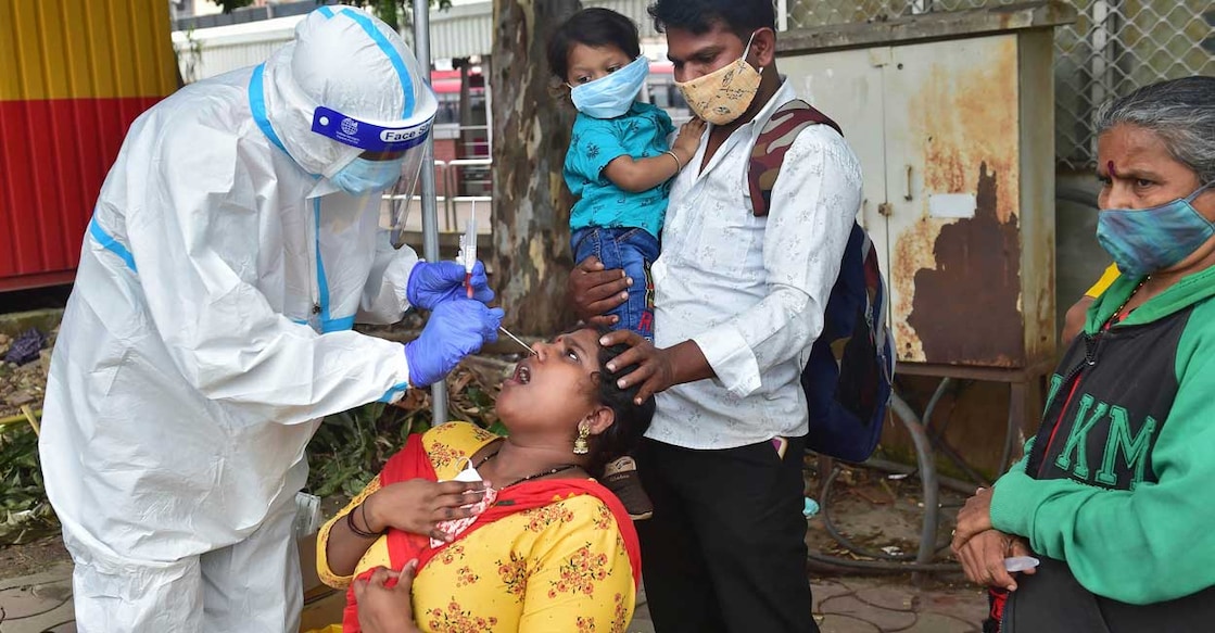 PTI11_28_2021_000120A A medic collects sample from a passenger for COVID-19 test, at KSRTC bus stand in Bengaluru, Sunday, Nov. 28, 2021. Photo: PTI/Shailendra Bhojak