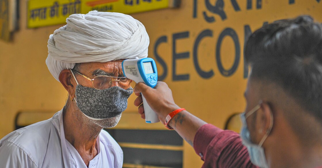 PTI12_07_2021_000141B A BMC health worker conducts thermal screening of an outstation passenger for COVID-19 testing, at Dadar Railway Station in Mumbai, Tuesday, Dec. 7, 2021. Photo: PTI/Shashank Parade
