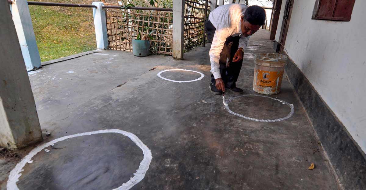 A worker makes circles at a polling centre to help voters maintain social distancing in the wake of the 2nd wave of Covid-19 pandemic across the country, on the eve of the 1st phase of polling for Assam elections, in Sivsagar district of Assam, Friday A worker makes circles at a polling centre to help voters maintain social distancing in the wake of the 2nd wave of Covid-19 pandemic across the country, on the eve of the 1st phase of polling for Assam elections, in Sivsagar district of Assam, Friday