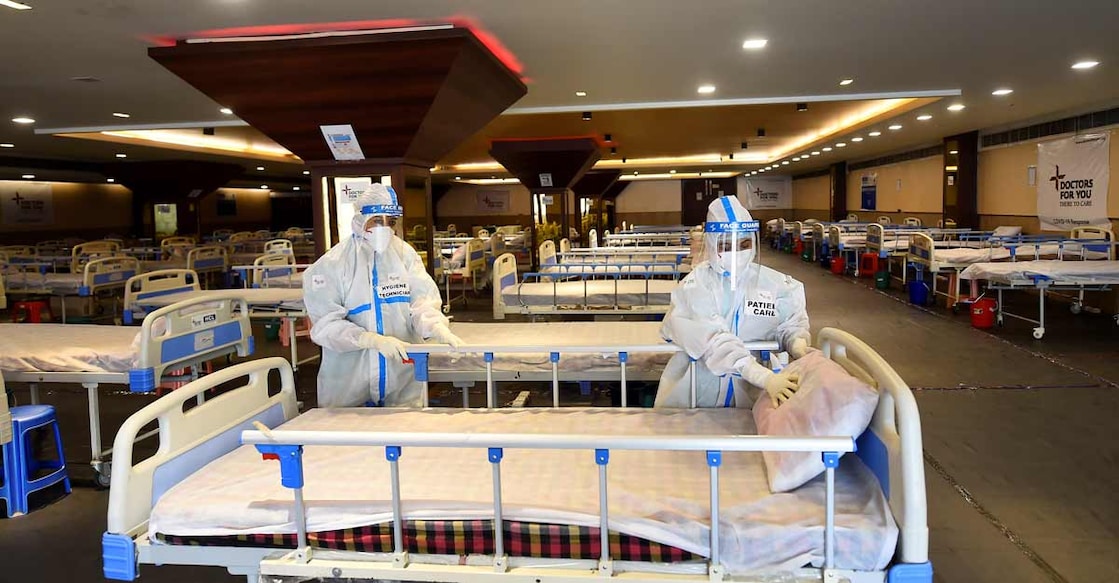 Workers prepare beds inside temporarily converted isolation ward for COVID-19 patients in Shehnai Banquet Hall opposite LNJP Hospital in New Delhi, Monday, April, 12, 2021. Photo: PTI
