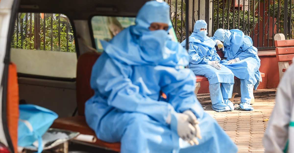 Family members, wearing PPE kits, wait during cremation of a COVID-19 victim, at the Nigambodh Ghat in New Delhi, Thursday, April 15, 2021. PTI