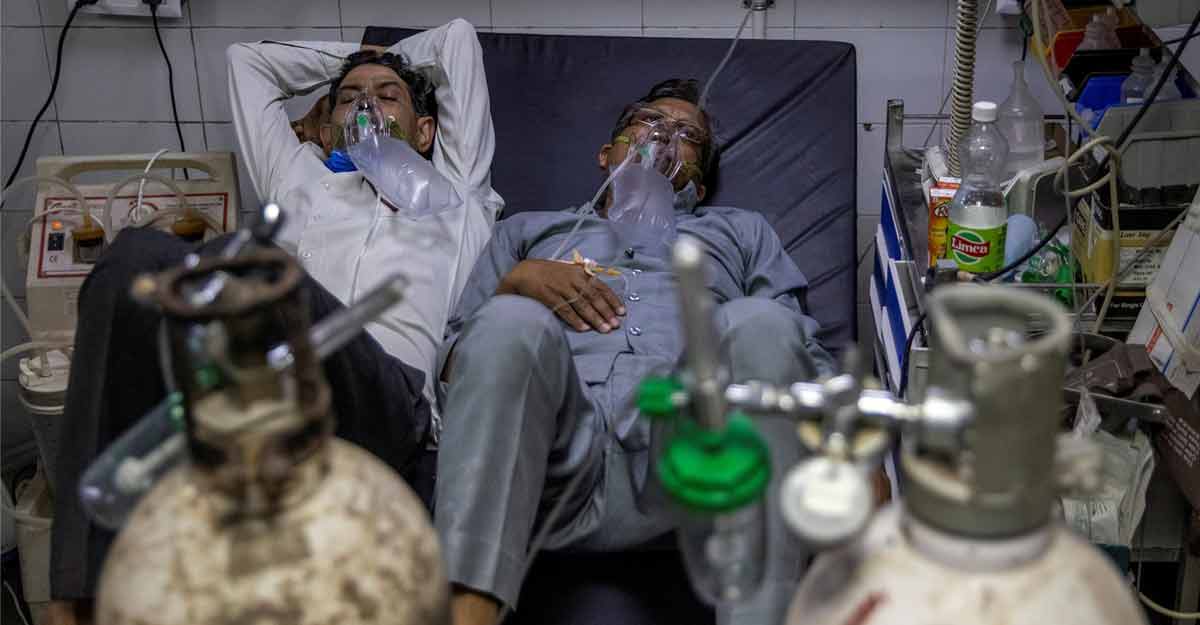 Patients suffering from COVID-19 share a bed as they receive treatment at the casualty ward in Lok Nayak Jai Prakash (LNJP) hospital in New Delhi, India April 15, 2021. REUTERS/Danish Siddiqui/File Photo