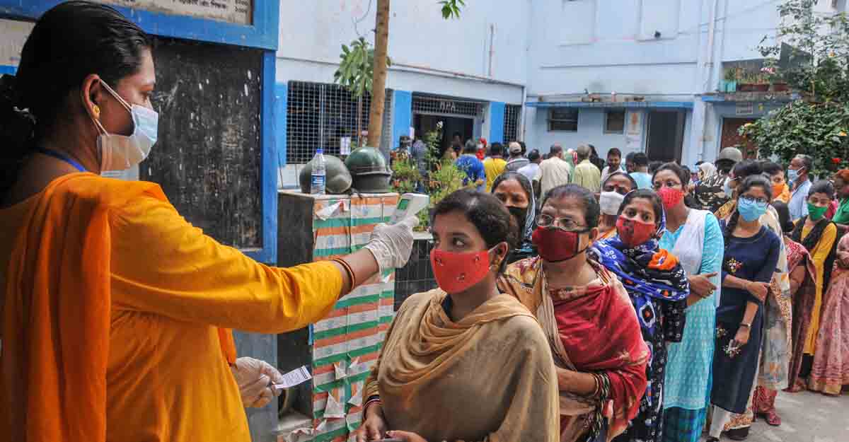 South 24 Parganas: Voters undergo thermal screening for as part of precautions against COVID-19 as they stand in a queue to cast their votes at a polling station during the third phase of West Bengal Assembly elections, at Baruipur in South 24 Parganas district, Tuesday, April 6, 2021. (PTI Photo) (PTI04_06_2021_000070B)