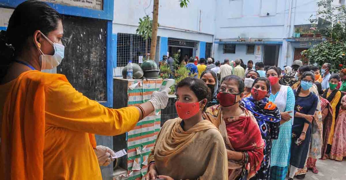 PTI04_06_2021_000070B South 24 Parganas: Voters undergo thermal screening for as part of precautions against COVID-19 as they stand in a queue to cast their votes at a polling station during the third phase of West Bengal Assembly elections, at Baruipur in South 24 Parganas district, Tuesday, April 6, 2021. (PTI Photo) (PTI04_06_2021_000070B)