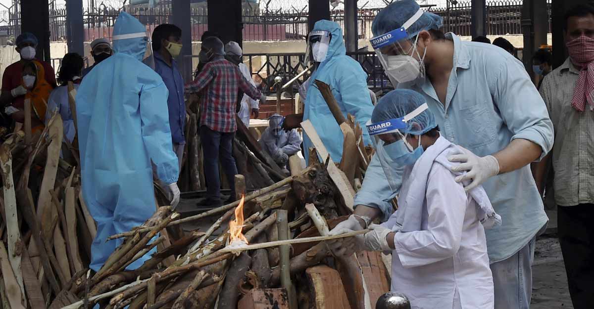 A boy performs last rites of a family member who died of COVID-19 at Nigambodh Ghat cremation ground, in New Delhi, Friday, May 14, 2021. Photo: Kamal Singh/PTI
