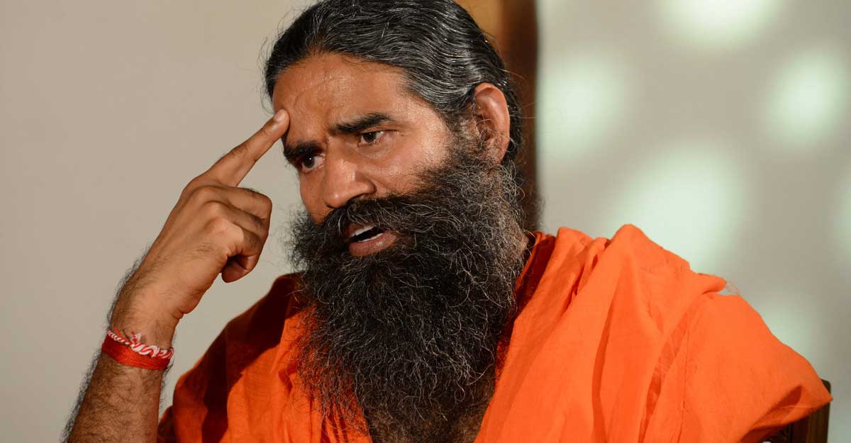 Yoga Guru Baba Ramdev gestures while giving an interview to a television channel after a press conference in Ahmedabad on May 10, 2017 . Photo by Sam Panthaky/AFP
