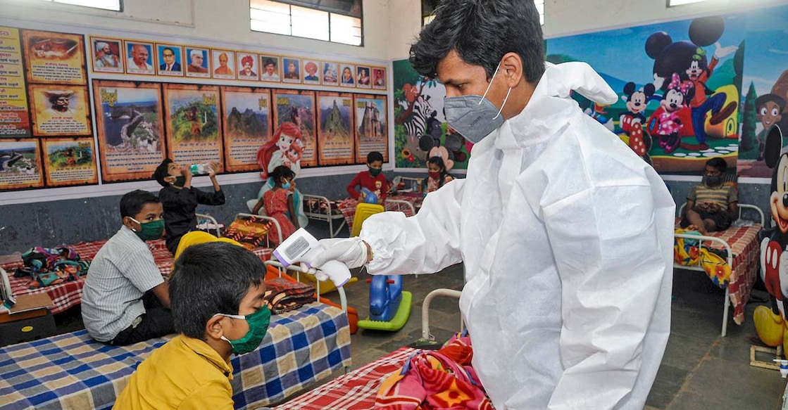 Children A medic conducts thermal screening of a child admiited at a COVID-19 care centre in Sangli. PTI