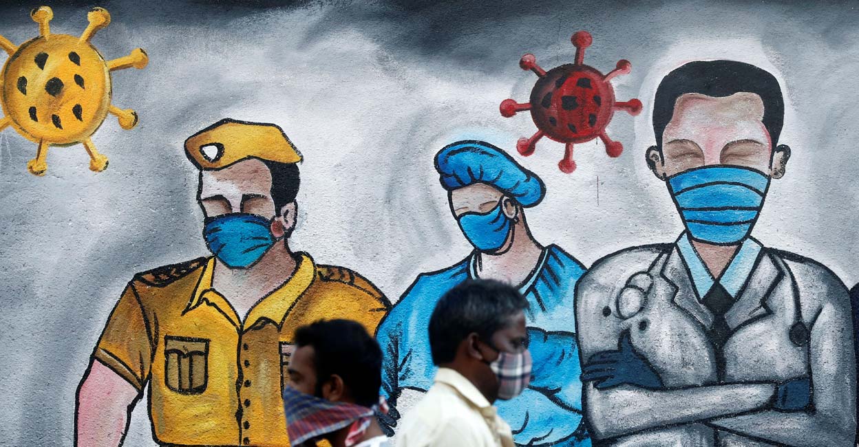 COVID Men walk past a mural of frontline workers amid the spread of the coronavirus disease (COVID-19), in Mumbai, India, December 21, 2020. Reuters/Francis Mascarenhas/Files