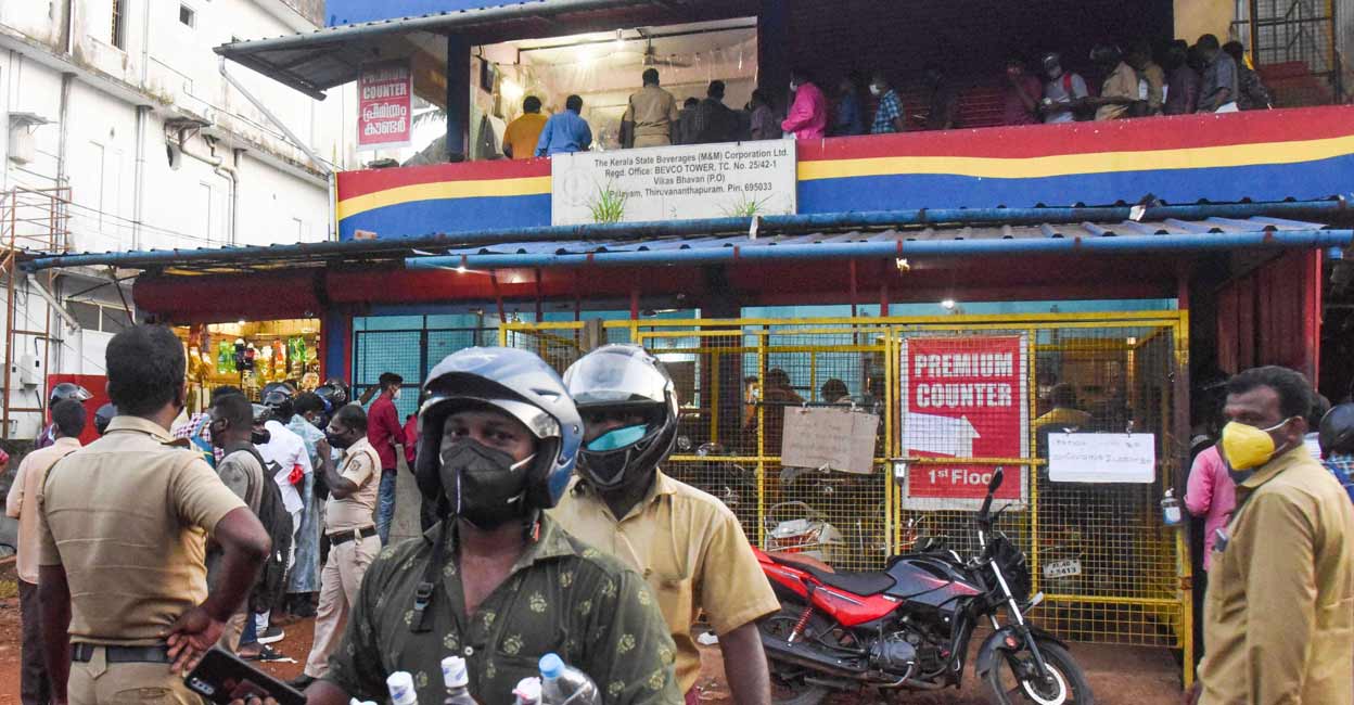 People crowd at a liquor shop after announcement of closure of beverage shops due to rise in COVID-19 cases, at Kalamassery in Ernakulam district, Friday, July 30, 2021. PTI