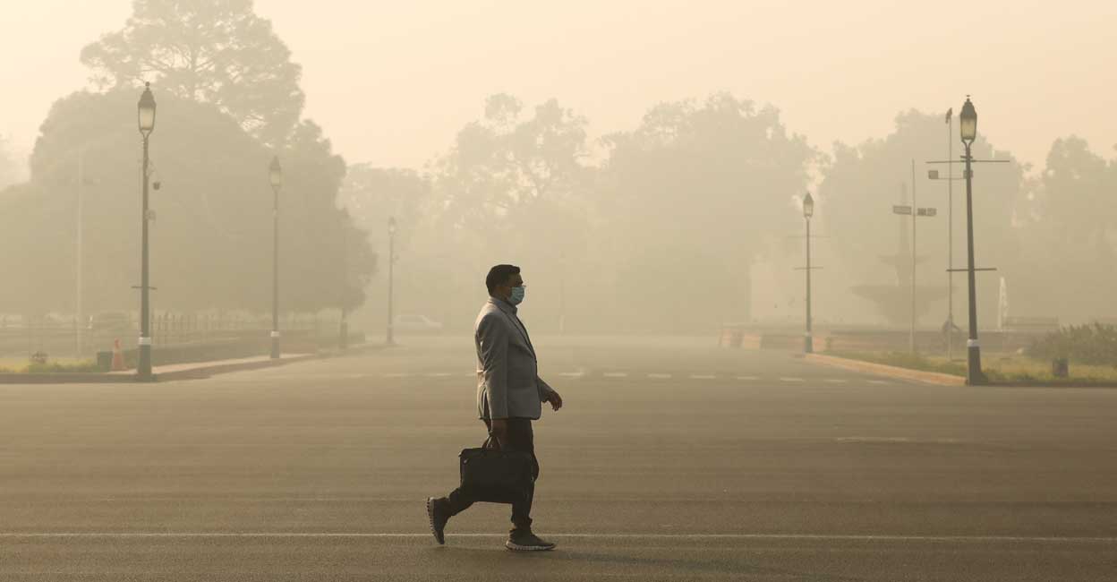 A man walks along a road on a smoggy morning in New Delhi, India, December 23, 2020. Reuters/Anushree Fadnavis/Files