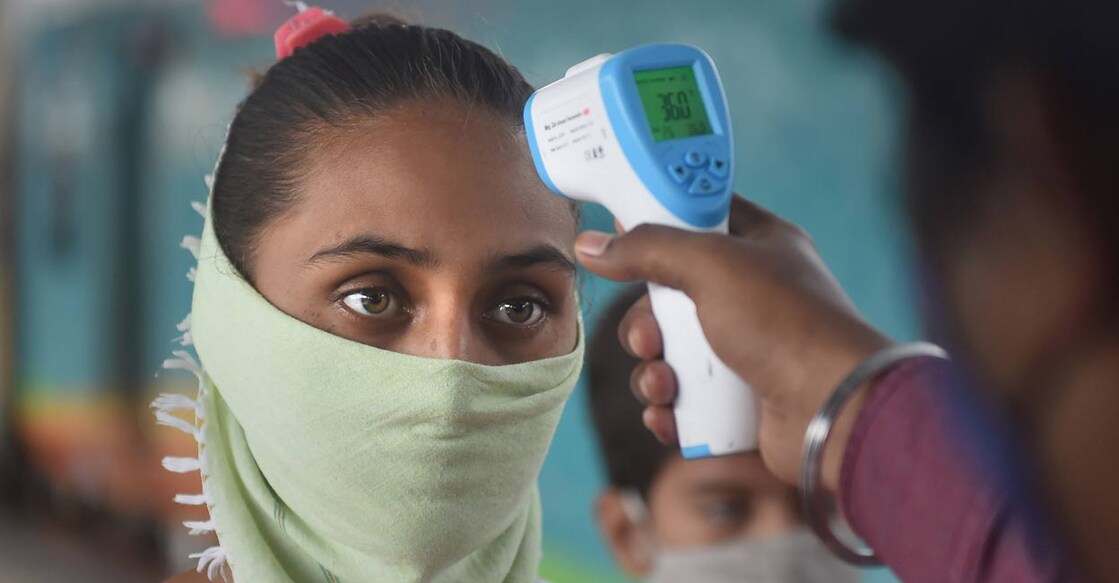 A BMC health worker conducts thermal screening of a passenger for COVID-19 testing, at Dadar Railway Station in Mumbai on Saturday, Sept. 11, 2021. PTI