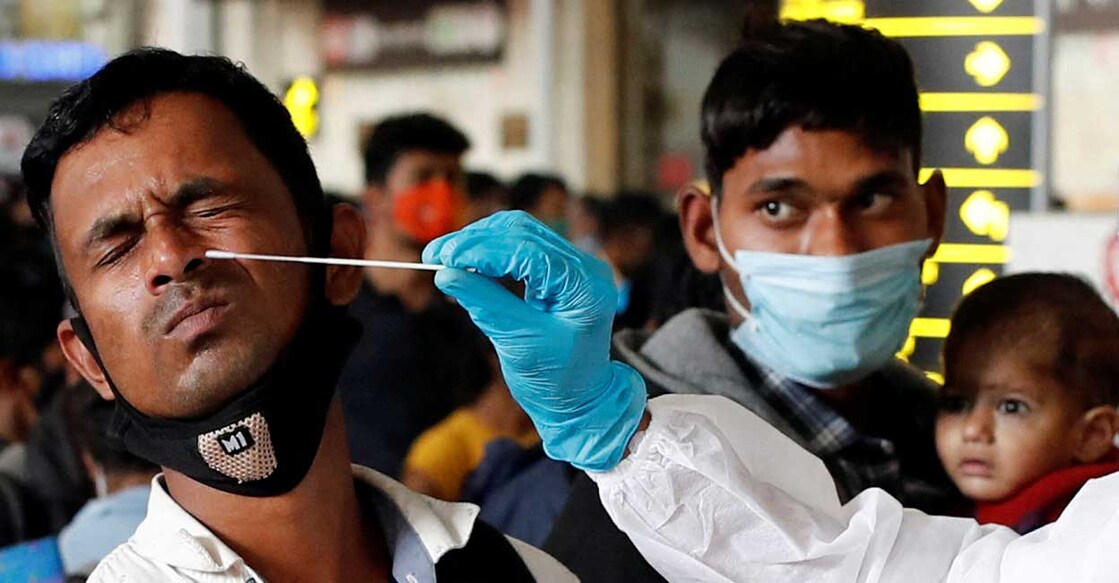 A man reacts as a health worker collects a swab sample during a rapid antigen testing campaign for coronavirus disease (COVID-19), at a railway station in Mumbai, India, January 13, 2022. Photo: Reuters/Francis Mascarenhas