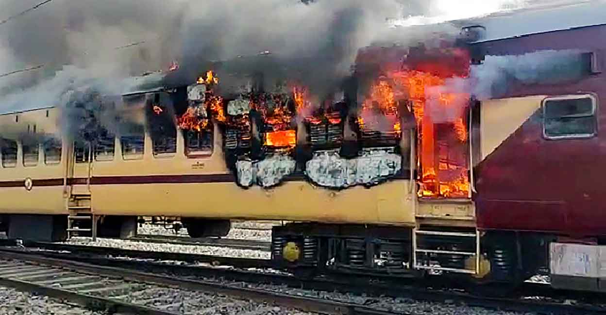 PTI01_26_2022_000299B A train burns after the aspirants set it on fire during their protest over alleged erroneousresults of Railway Recruitment Boards-Non Technical Popular Categories(RRB-NTPC) exams, at Gaya Junction railway station, Wednesday, January 26, 2022. PTI