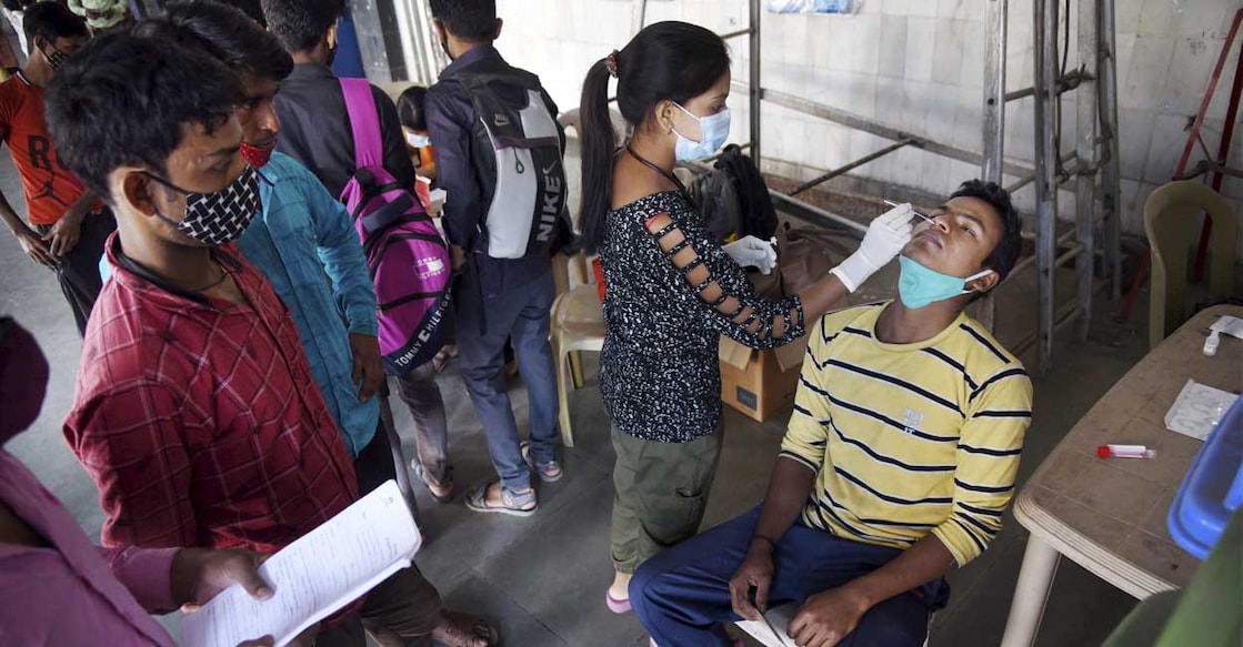 A medic from NMMC Health Department collects swab sample of a man for COVID-19 test, at Nerul railway station in Navi Mumbai, Saturday, Jan. 29, 2022. PTI